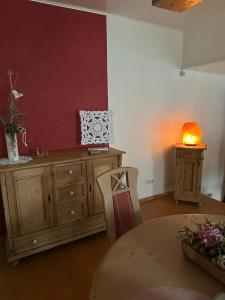 a dining room with a table and a red wall at Ferienwohnung Riva in Kronau