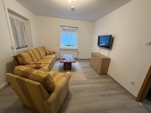 a living room with two couches and a flat screen tv at Fewo am Rammelsberg in Goslar