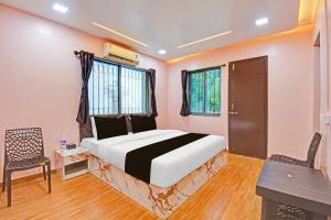a bedroom with a bed and a table and chairs at Hotel O The Heaven in Pune