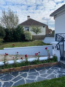 a garden with red flowers and a white fence at Maison individuelle, 3chambres, avec parking in Le Grand-Quevilly