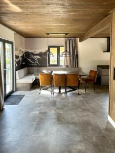 a living room with a dining room table and chairs at Chalet am See! in Afritz