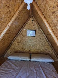 ein Bett in einem Holzrahmenzelt mit einem Fernseher darin in der Unterkunft Cabana Ipê - Nosso Quintal Candeias in Conceição do Mato Dentro