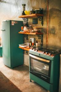 eine Küche mit einem grünen Herd und einem Kühlschrank in der Unterkunft Cabana Ipê - Nosso Quintal Candeias in Conceição do Mato Dentro