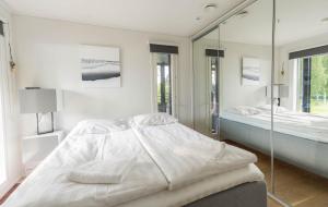 a white bedroom with two beds and a mirror at Exclusive Villa Wikkelä Ranua with Sauna & Jacuzzi in Ranua