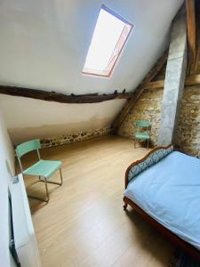a bedroom with a bed and a chair in a attic at La Grange in Thollet