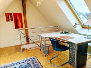 an attic office with a desk and a chair at ZEN Apartment 2 rooms Maisonette Bright and Spacious in Karlsruhe