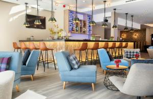 ein Restaurant mit blauen Stühlen und einer Bar in der Unterkunft Leonardo Hotel Hannover in Hannover + 98 Fotos