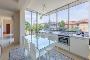 une grande cuisine avec une table et des chaises en verre dans l'établissement Penthouse Milan Center Jacuzzi & Garage, à Milan
