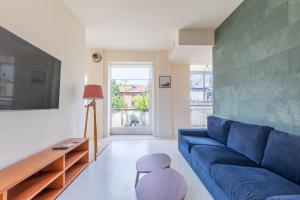 un salon avec un canapé bleu et une table dans l'établissement Penthouse Milan Center Jacuzzi & Garage, à Milan