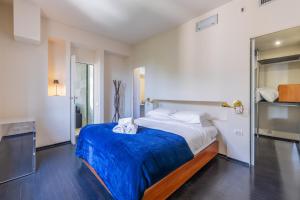 une chambre avec un grand lit avec une couverture bleue dans l'établissement Penthouse Milan Center Jacuzzi & Garage, à Milan