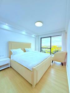 a bedroom with a large bed and a large window at Pearl Luxe Homes at Orchid Residency - Spacious 2BR in Westlands With Pool, Gym, Rooftop views & breakfast café in Nairobi +18 photos