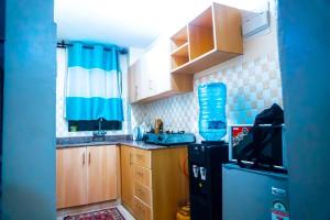 a small kitchen with wooden cabinets and a refrigerator at Abitana Luxury Apartments in Nairobi