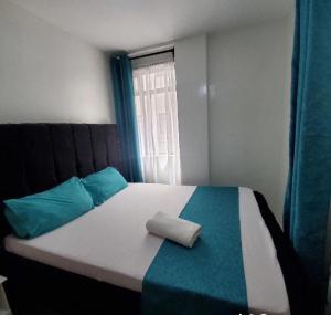 a bed with two pillows on top of it with a window at Abitana Luxury Apartments in Nairobi