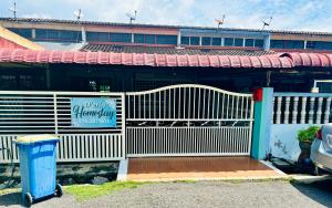 a white fence in front of a building at D Erin Homestay in Banting