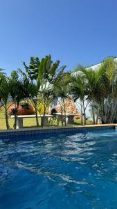 una piscina con palme sullo sfondo di ECR Beach Villa with Private Swimming Pool a Tirupporūr