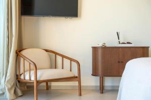 una silla sentada en una habitación junto a un tocador en New Villa - Rooftop Jacuzzi & Sunset Views, en Santa Bárbara de Nexe