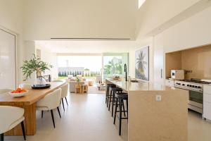 Una cocina y un comedor con mesa y sillas. en New Villa - Rooftop Jacuzzi & Sunset Views, en Santa Bárbara de Nexe