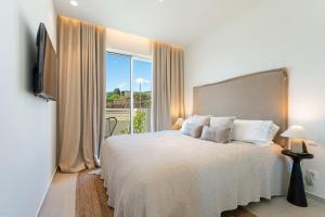 Un dormitorio con una cama y una ventana grande en New Villa - Rooftop Jacuzzi & Sunset Views, en Santa Bárbara de Nexe 25 fotos más