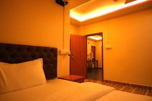a bedroom with a bed and a door to a hallway at Raindrop Homestay Havelock in Sir William Peel Island +3 photos