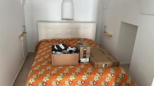 two boxes sitting on a bed in a room at - Tiny House Myrtus - in Palazzo d'epoca in pieno centro storico by APE in Terlizzi