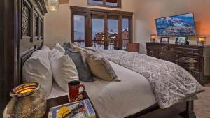 a bedroom with a large white bed and a table at Appaloosa Mountain Lodge in Steamboat Springs +26 photos
