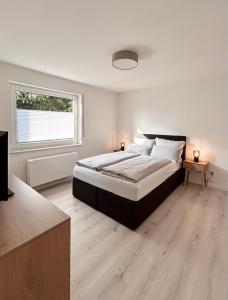 a bedroom with a large bed and a window at Waldblick Hilgert - Moderne FeWo im Westerwald 