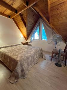 a bedroom with a bed and a desk and a window at Casa Matteo con quincho, patio y cochera in Las Grutas