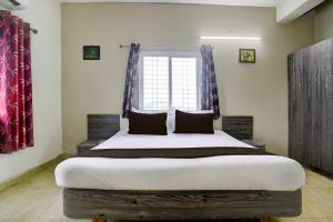 a bedroom with a large bed in front of a window at Hotel O Silver Sky in Gulbarga