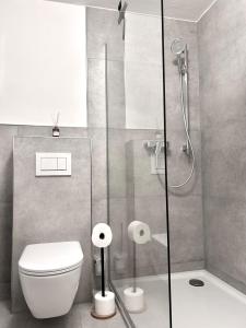 a bathroom with a toilet and a glass shower at Waldblick Hilgert - Moderne FeWo im Westerwald 