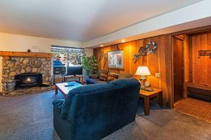 un soggiorno con un divano blu e un camino di Horizons 4 - Pool & Hot Tub Access a Mammoth Lakes