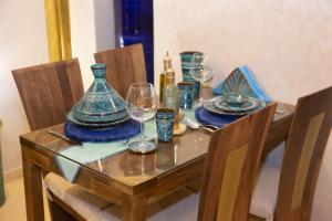 un tavolo con piatti e bicchieri da vino sopra di Riad La Rose Orientale Marrakech a Marrakech Altre 10 foto