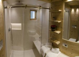 un bagno con doccia, WC e lavandino di Ca novella sulla Passeggiata a Cortina dʼAmpezzo Altre 15 foto