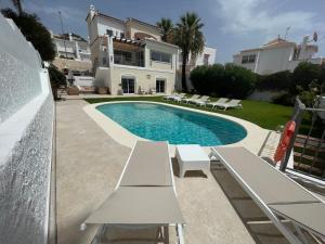 a villa with a swimming pool in front of a house at Charming villa in Nerja in Nerja