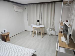 釜山にある태양스테이모텔 남포중앙점の白い部屋(テーブル、ベッド付) +4枚の写真
