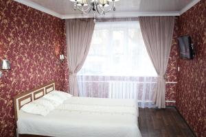 a bedroom with a bed and a window at Шикарный ВИП в самом центре Караганды по улице Ерубаева in Karagandy