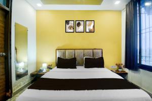 1 dormitorio con 1 cama grande y 3 cuadros en la pared en Hotel O JAIPUR ONE, en Jaipur