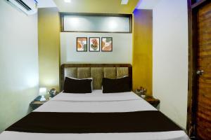 1 dormitorio con 1 cama blanca grande con almohadas negras en Hotel O JAIPUR ONE, en Jaipur