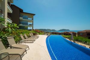 une rangée de chaises assises à côté d'une piscine dans l'établissement Montecielo 3E 3bdrs ocean view in Los Suenos, à Herradura