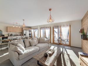 ein Wohnzimmer mit Sofa und Tisch in der Unterkunft Appartement au pied des pistes - 6 adultes + 2 enfants, 4 chambres, parking, wifi - FR-1-570-40 in Levassaix + 5 Fotos