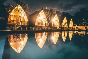 a row of houses with lights in the water at night at Island Beach Bungalow in Gili Trawangan