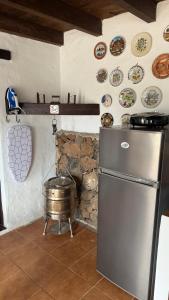 a kitchen with a refrigerator and a barrel and plates on the wall at Loft Tortuga in Tinajo