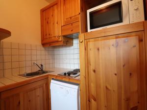 a small kitchen with a sink and a microwave at Confortable 2 Pièces avec Balcon, Wi-Fi et Animaux admis - FR-1-182-7 in Méribel +13 photos