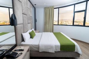 a bedroom with a bed and a desk with a phone at Hotel Plaza Monte Carlo in Guayaquil