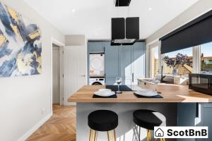 a kitchen with blue cabinets and a table with stools at Contractor Housing - Parking - Long Stay Discounts in Aberdeen +20 photos
