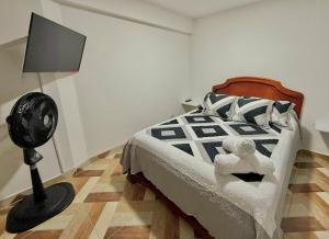 a bedroom with a bed with a fan and a lamp at GURUS FR Luminoso Amplio Cómodo en excelente ubicación in Pereira