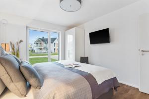 TV a/nebo společenská místnost v ubytování Ferienhaus Kaptains Strandhuus Olpenitz