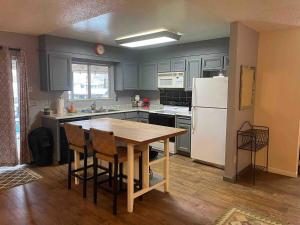 Clearlake OaksにあるCozy lake home with indoor fireplace & dockのキッチン(木製テーブル、白い冷蔵庫付)