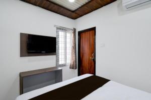 Un dormitorio con una cama y un televisor de pantalla plana. en HOTEL O DEVARA GRAND, en Maula Ali