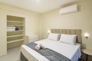 a bedroom with a white bed and a closet at Apto c/ 1 Suíte a 90 m da Praia SEM0012 in Barra Velha