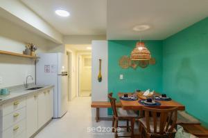 Una cocina con una mesa de madera y una pared verde. en Apartamento con 1 Suite a 90 m de la Playa SEM0012, en Barra Velha